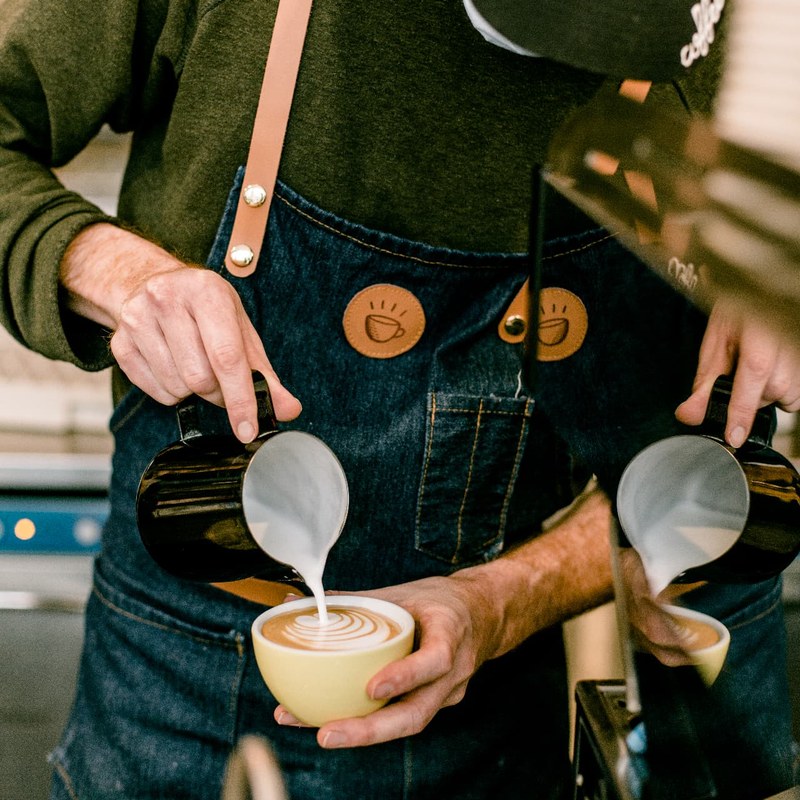 Barista versant le lait dans une tasse