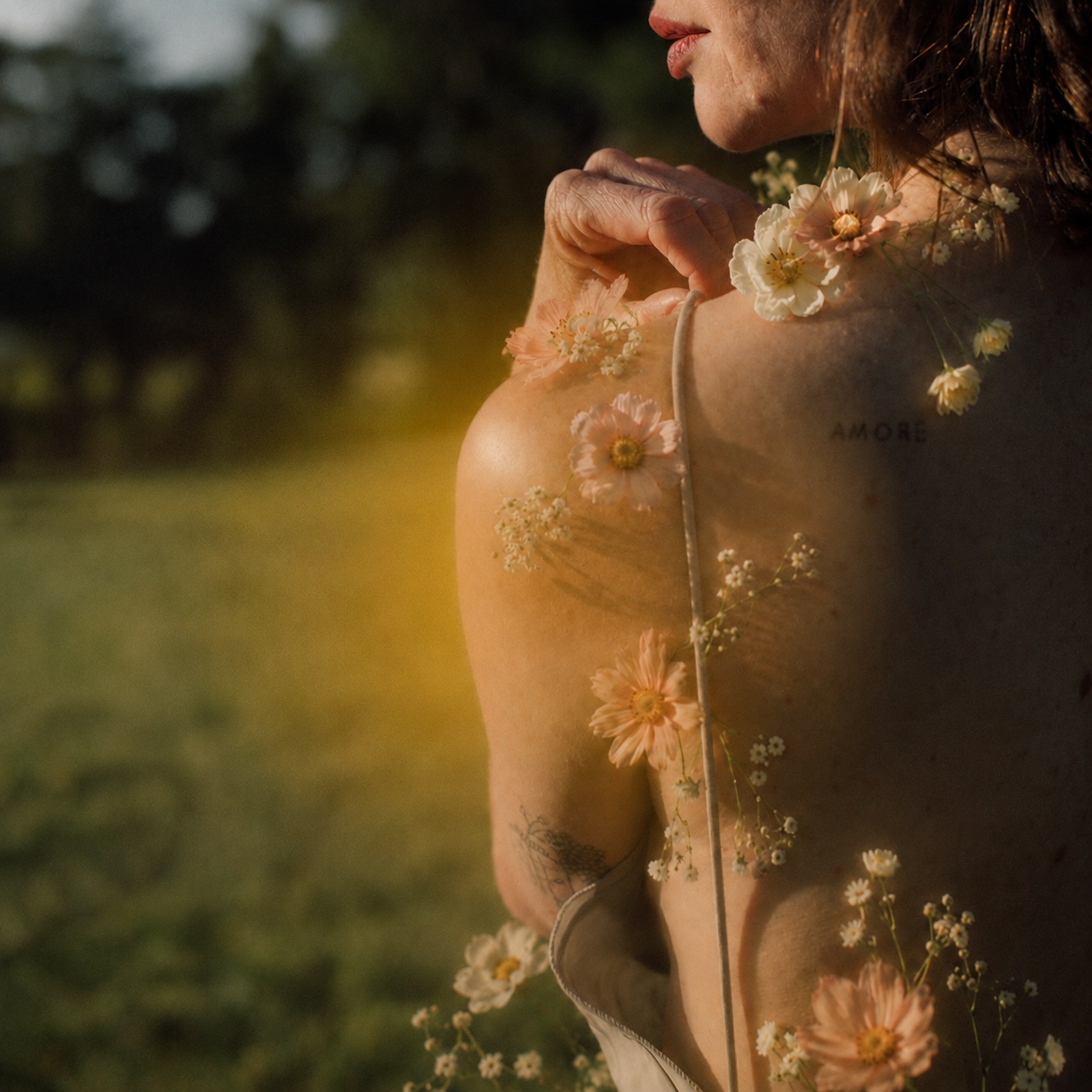 Portrait onirique d'une femme de dos, fleurs posées sur la peau