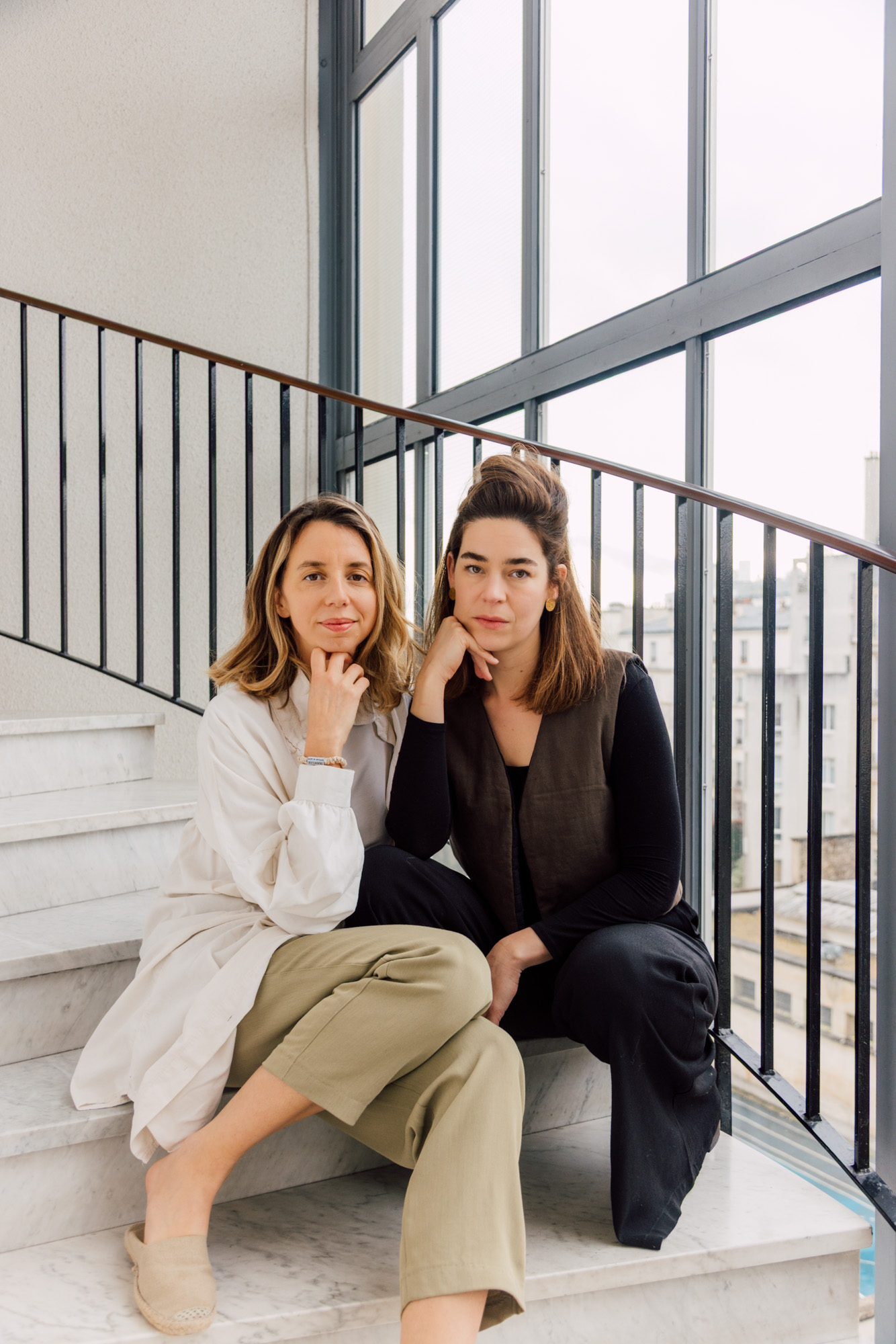 Deux femmes assises dans un escalier lumineux